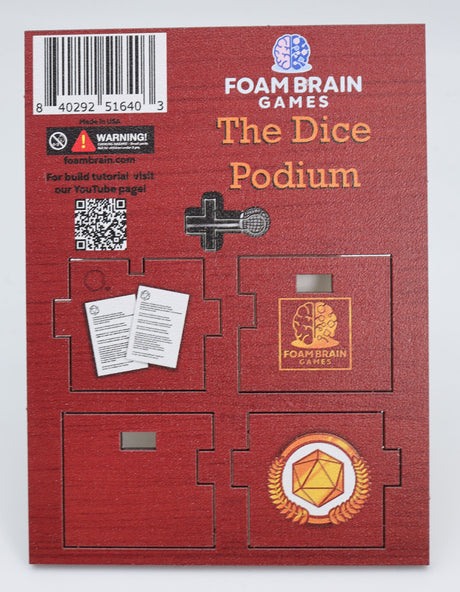 Unassembled MDF Wooden board "Foam Brain Games The Dice Podium" printed on top, QR Code leading to assembly instructions on youtube channel, pieces of podium on board, brown on brown wood-like background