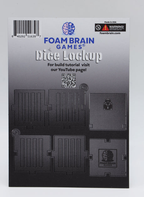 Unassembled MDF Wood board "Foam Brain Games Dice Lock up" printed on. QR code for assembly instructions printed, pieces of dice lock up on board gray, gray to white gradient background